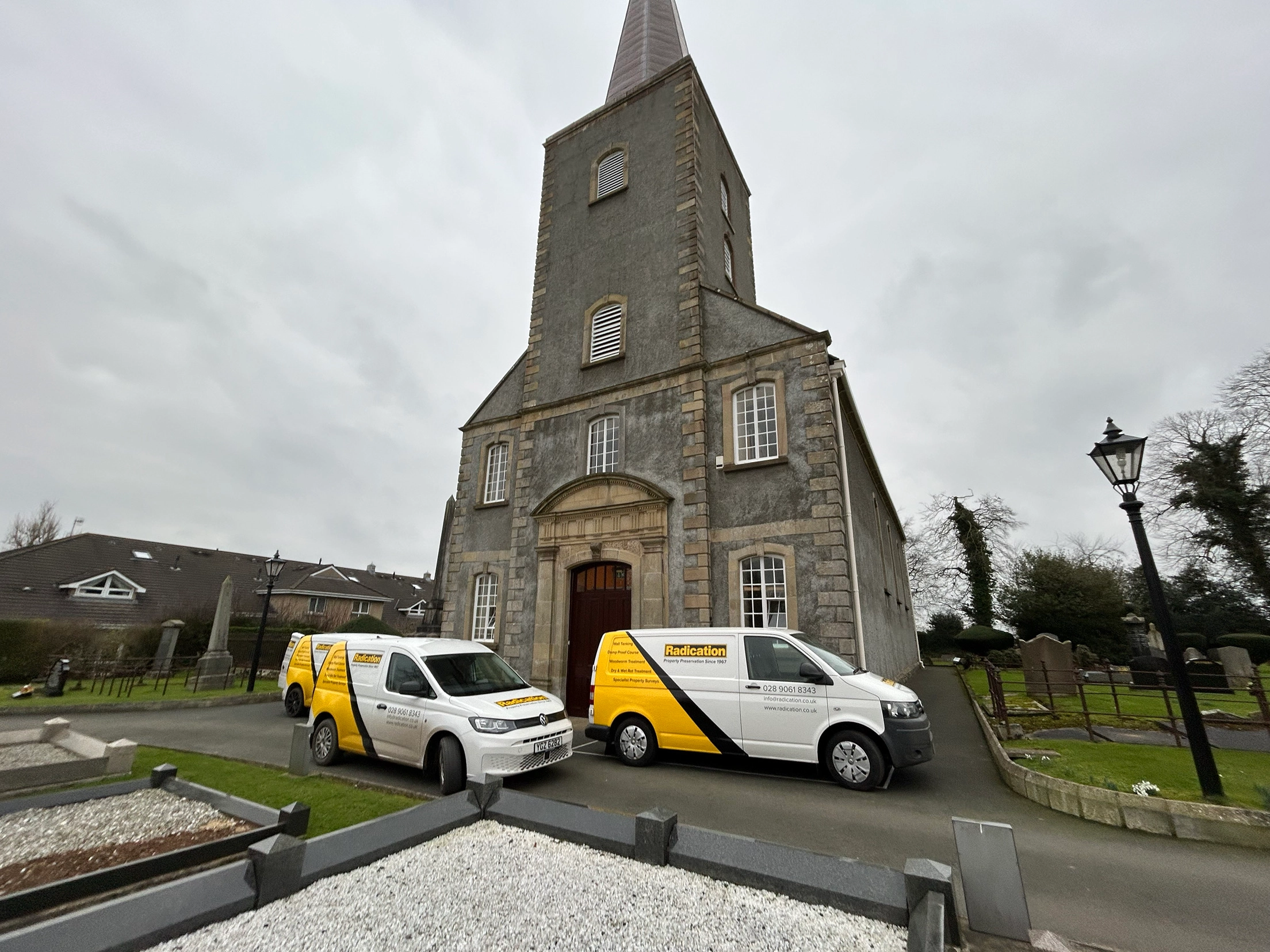 Radication Ltd vans outside St John's Parish Church, Moira, during woodworm treatment to the bell tower timbers